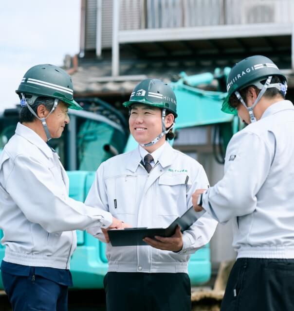 解体現場で笑顔で会話をする3人