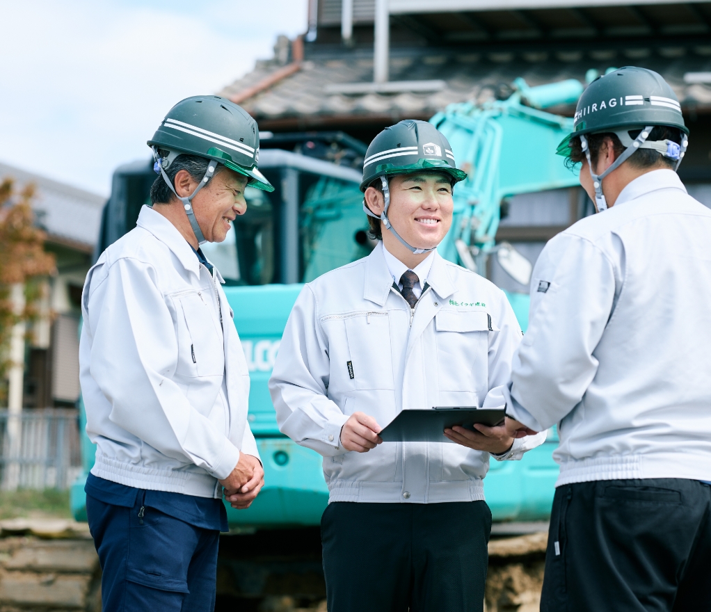 解体現場で笑顔で会話をする3人